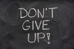 motivational phrase, don't give up, handwritten with white chalk on a blackboard