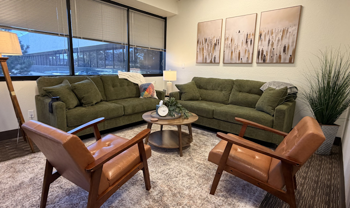 Warmly lit large counseling room designed like a welcoming living room