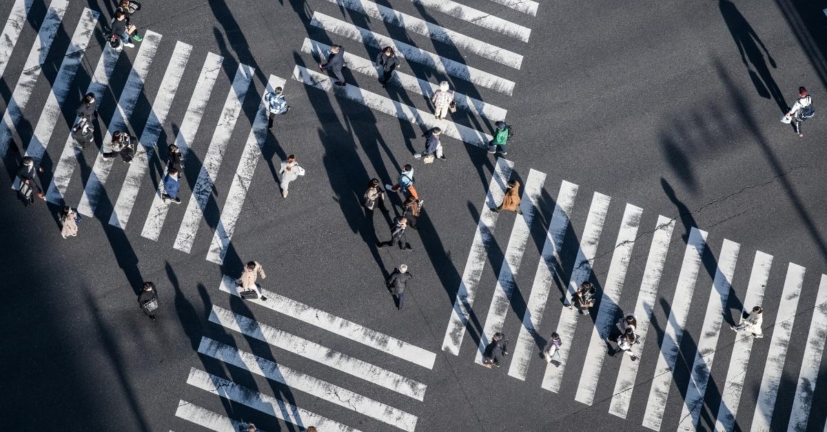 Top-down view of Pedestrians crossing the street at a busy intersection in Ginza, a popular upscale shopping area of Tokyo, Japan.