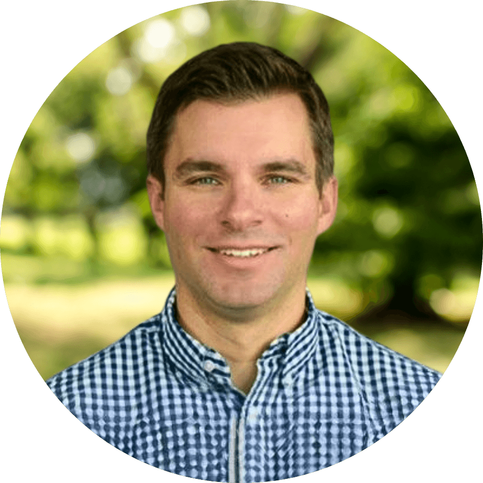 Joshua Morgan smiles in front of a green nature background