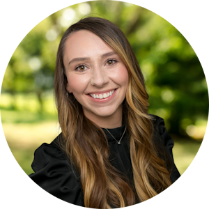 Counselor Katie Anderson smiles front of a green nature background
