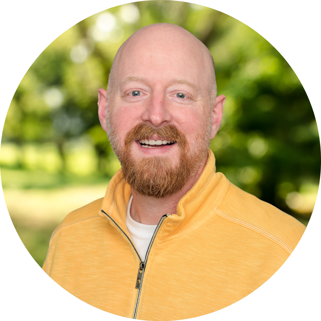 Pleasantly smiling male counselor with beard in a yellow sweater