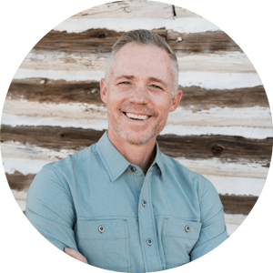 Headshot of Sean F. Taylor (LMFT, Christian counselor) in front of a wall of wooden logs or planks