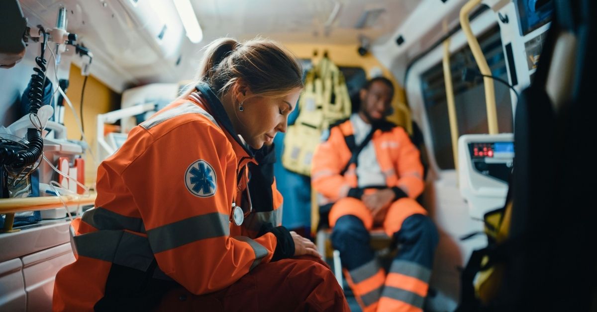 Tired first responder female and male EMS inside ambulance